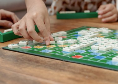 Hands playing scrabble tiles