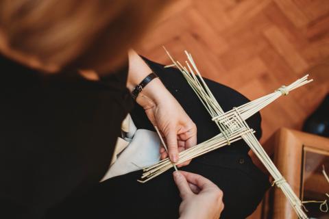 Woman making St Brigids Cross