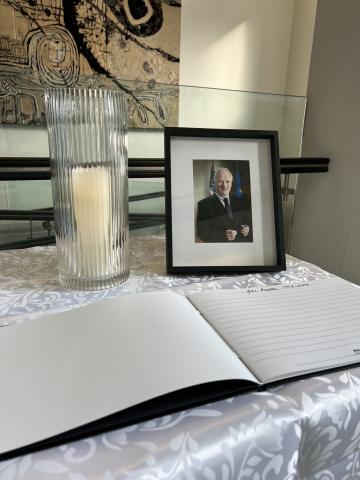 Book of condolence on table with photo of John Bruton and candle