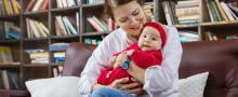 Young woman holding baby in library