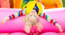 Child upside down on bouncy castle facing camera