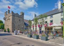 photograph taken from the road showing Dalkey Castle to the left of the frame, with the Queen's Pub to the right. 