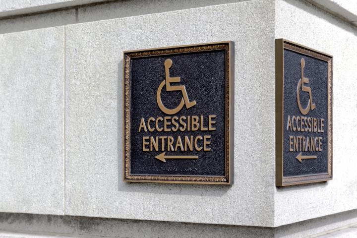 Accessible entrance sign containing wheelchair image Accessible entrance sign